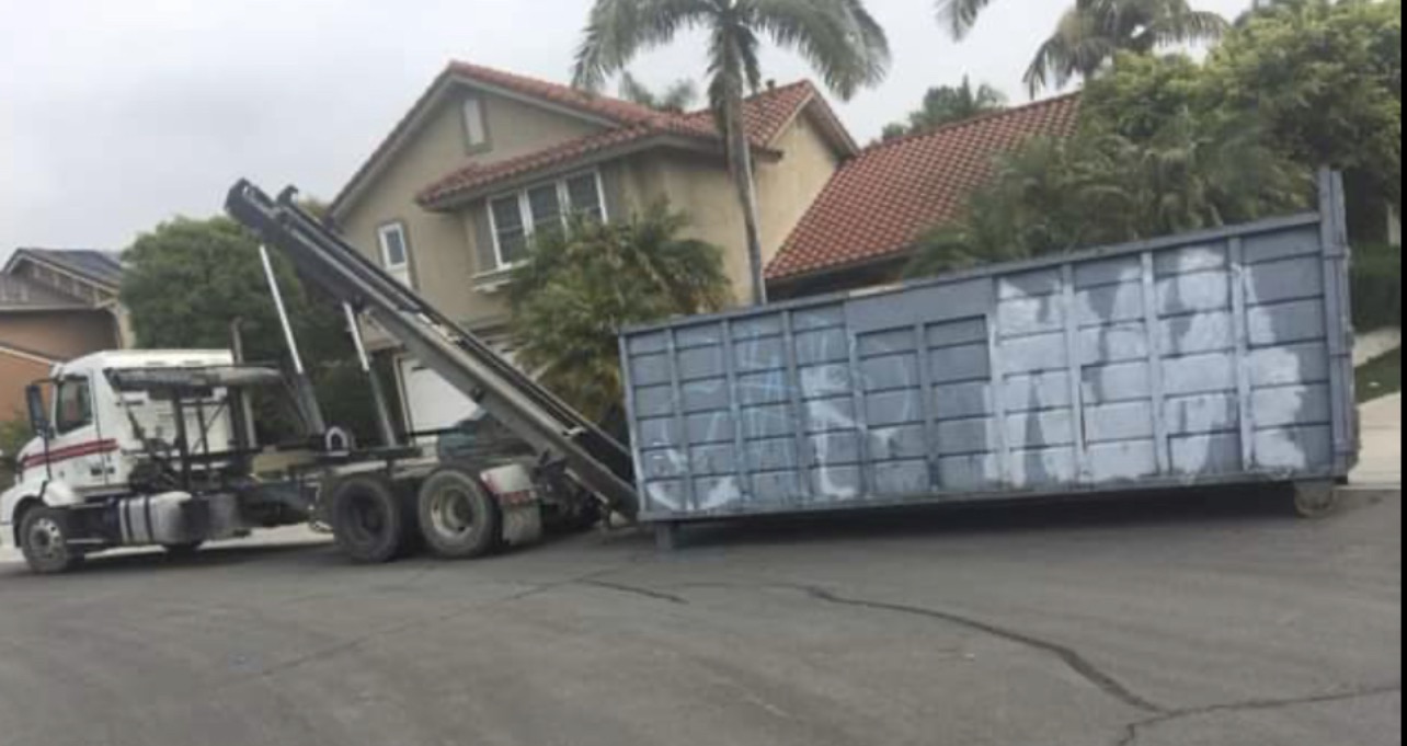 RDO truck picking up a roll-off container
